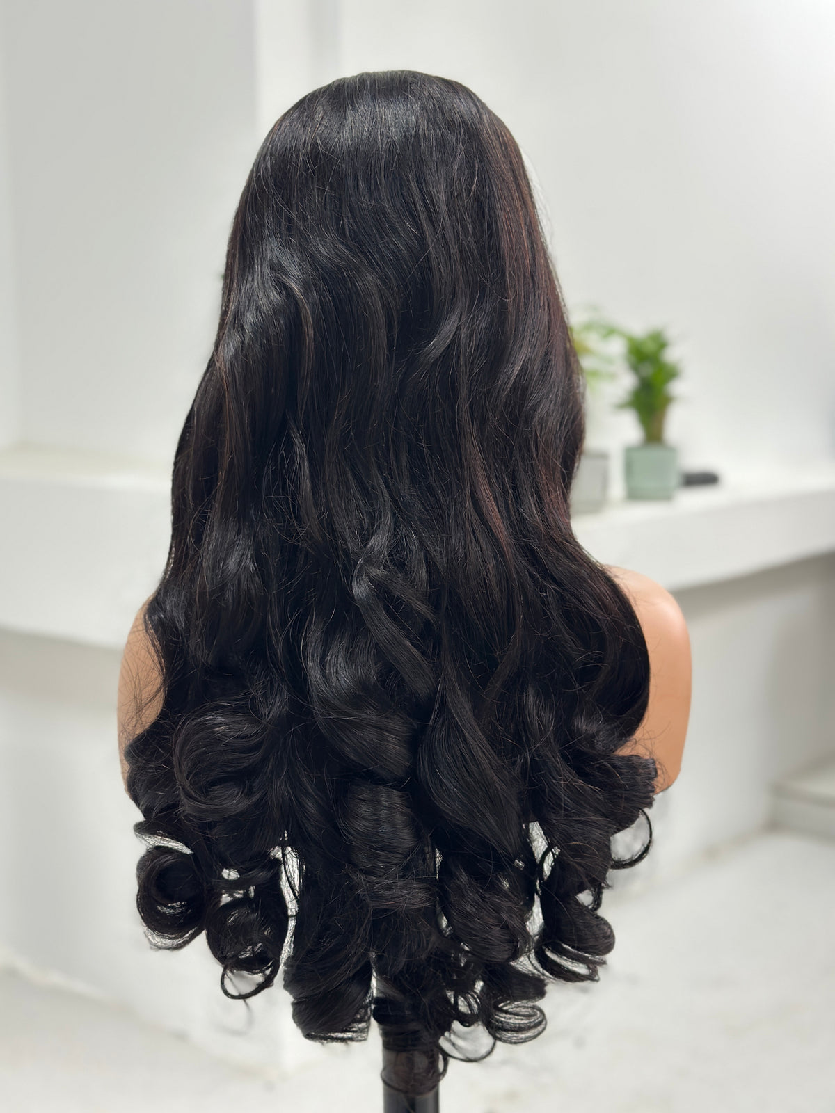 Back view showing long loose curls on UNices Hair 26 inch human hair wig