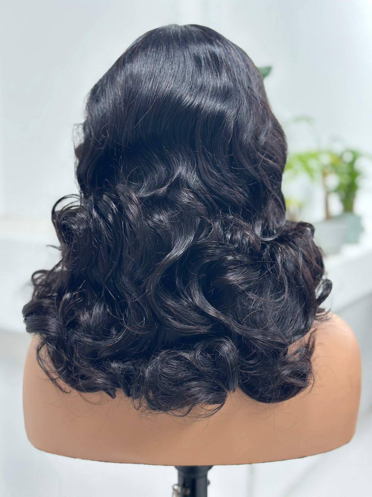 Back view of UNices Hair natural black loose curl human hair wig